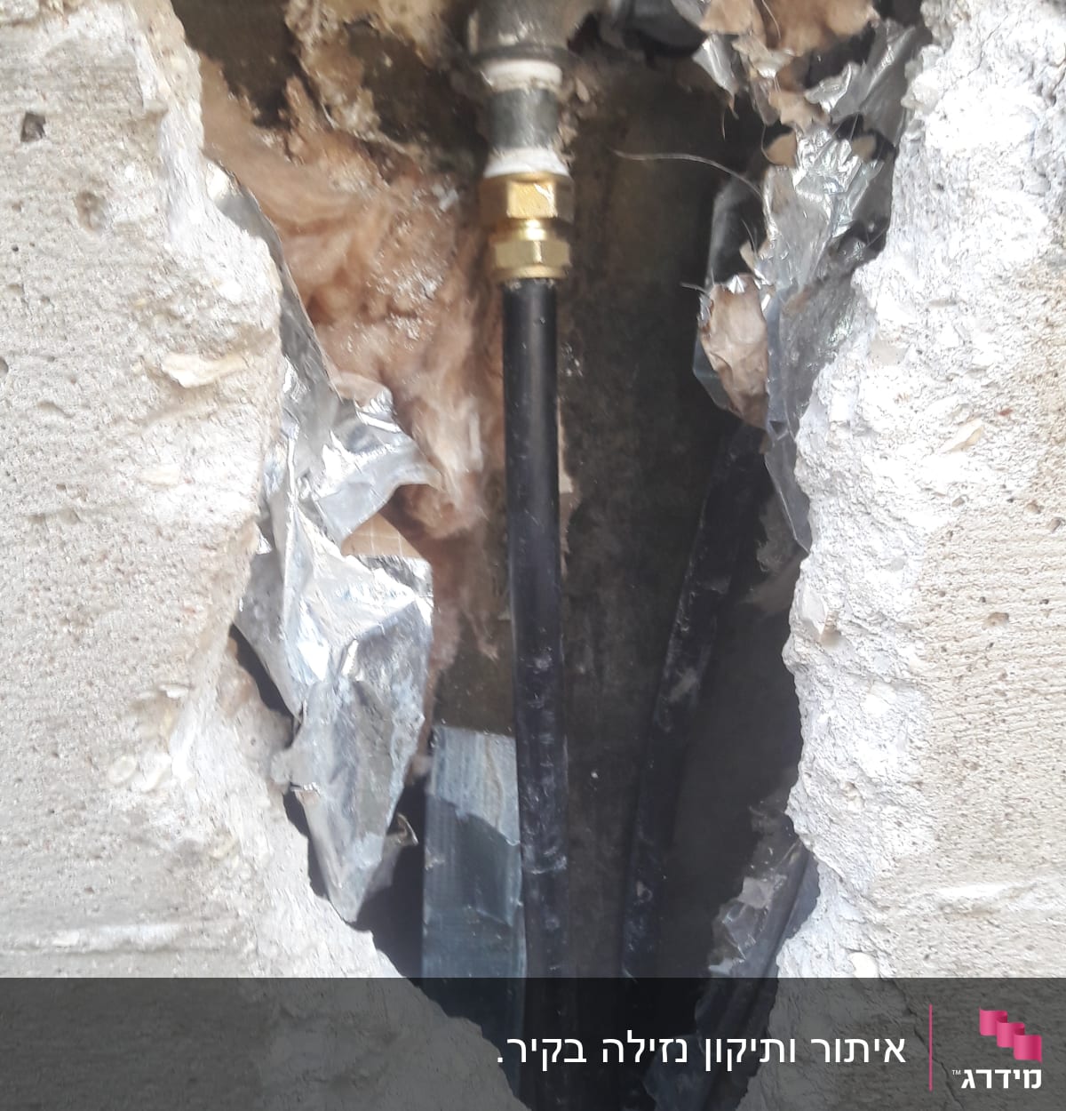 צינור מים עם חיבורי מתכת בקיר שבור